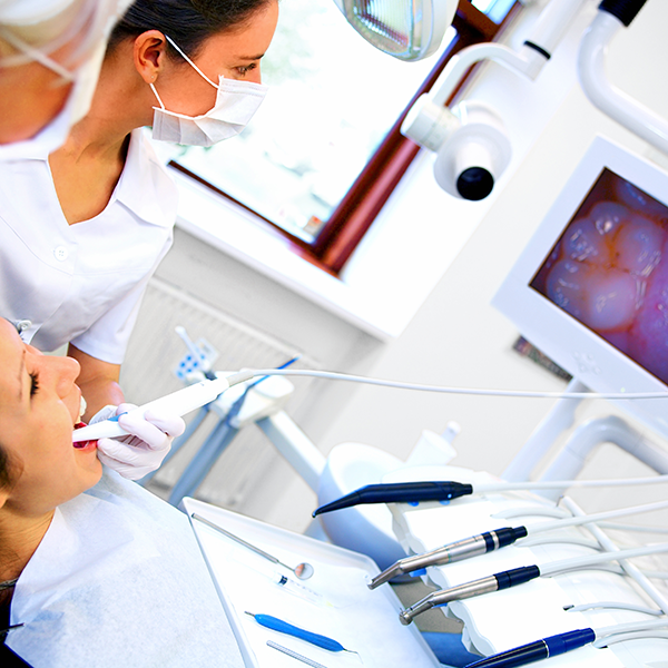Dental assistant showing patient intra-oral photos